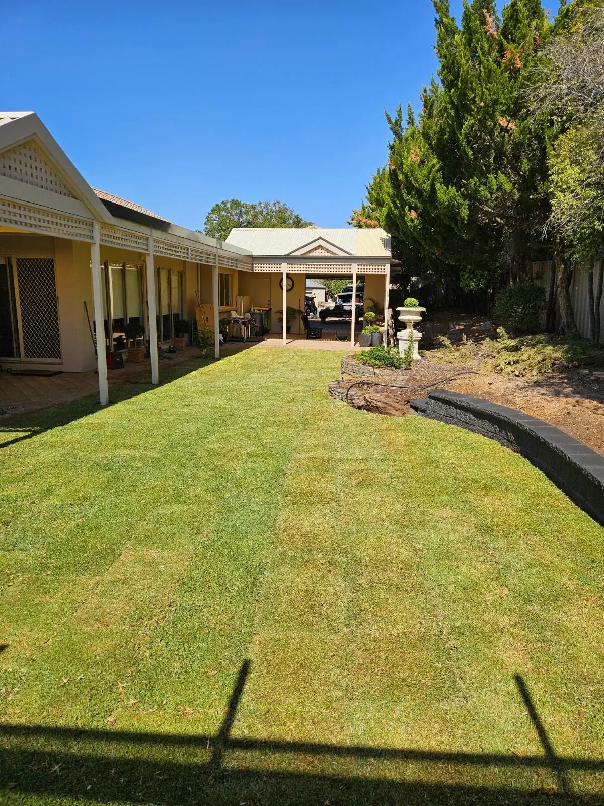 Freshly laid backyard lawn running along a home's veranda