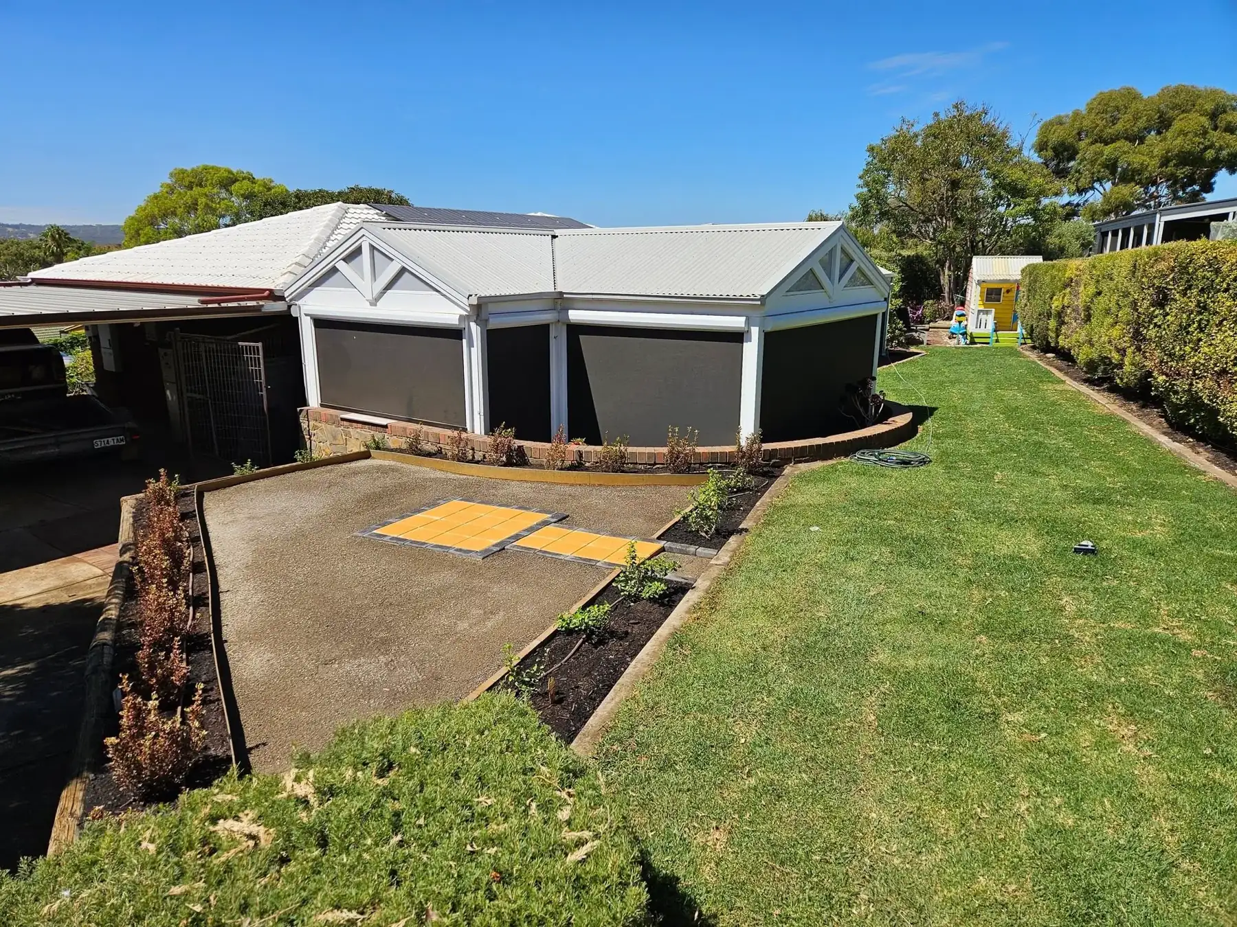Backyard with new turf, edged garden beds and a pergola