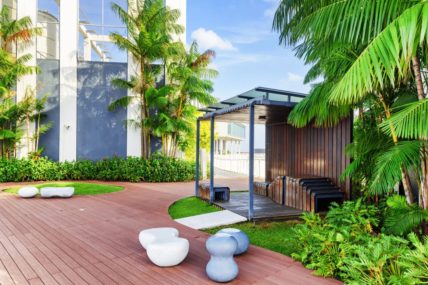 Commercial courtyard with timber decking, a pergola pavilion and tropical planting