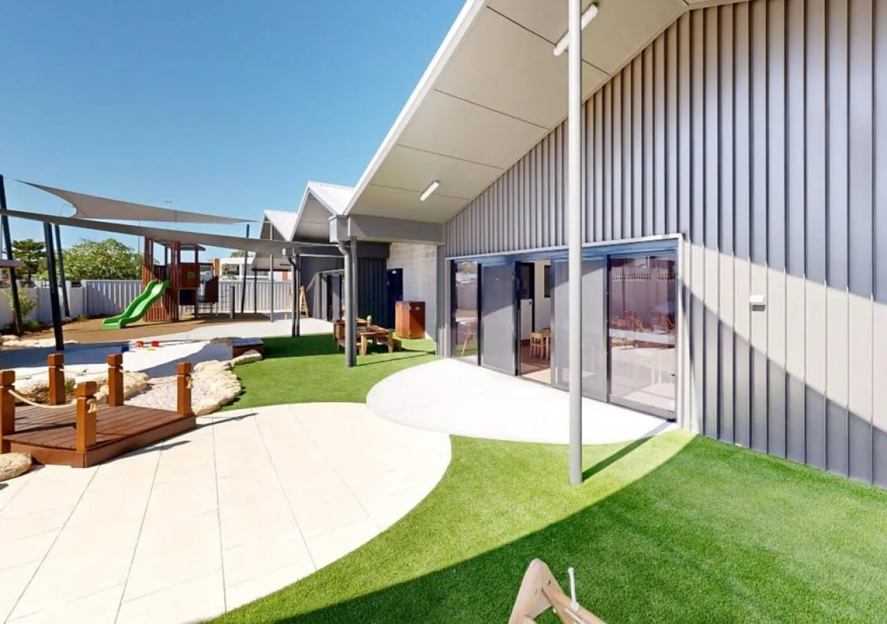 Commercial building with synthetic turf, paved paths and shade sails