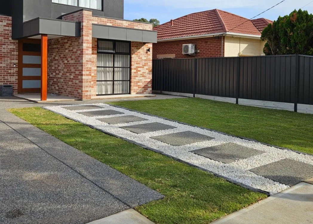 Front yard with concrete stepping stones set in turf and gravel