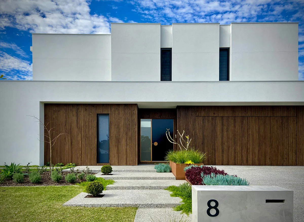 Modern home entry with low rendered walls, gravel garden and stepping pavers