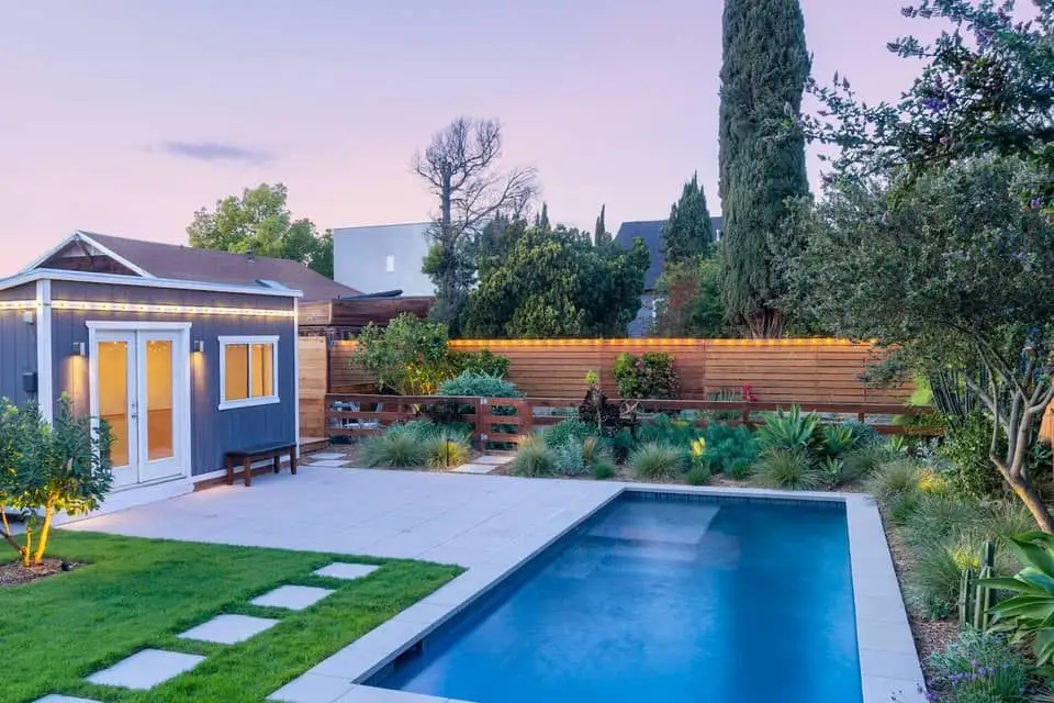 Backyard pool with stepping-stone lawn path and garden studio