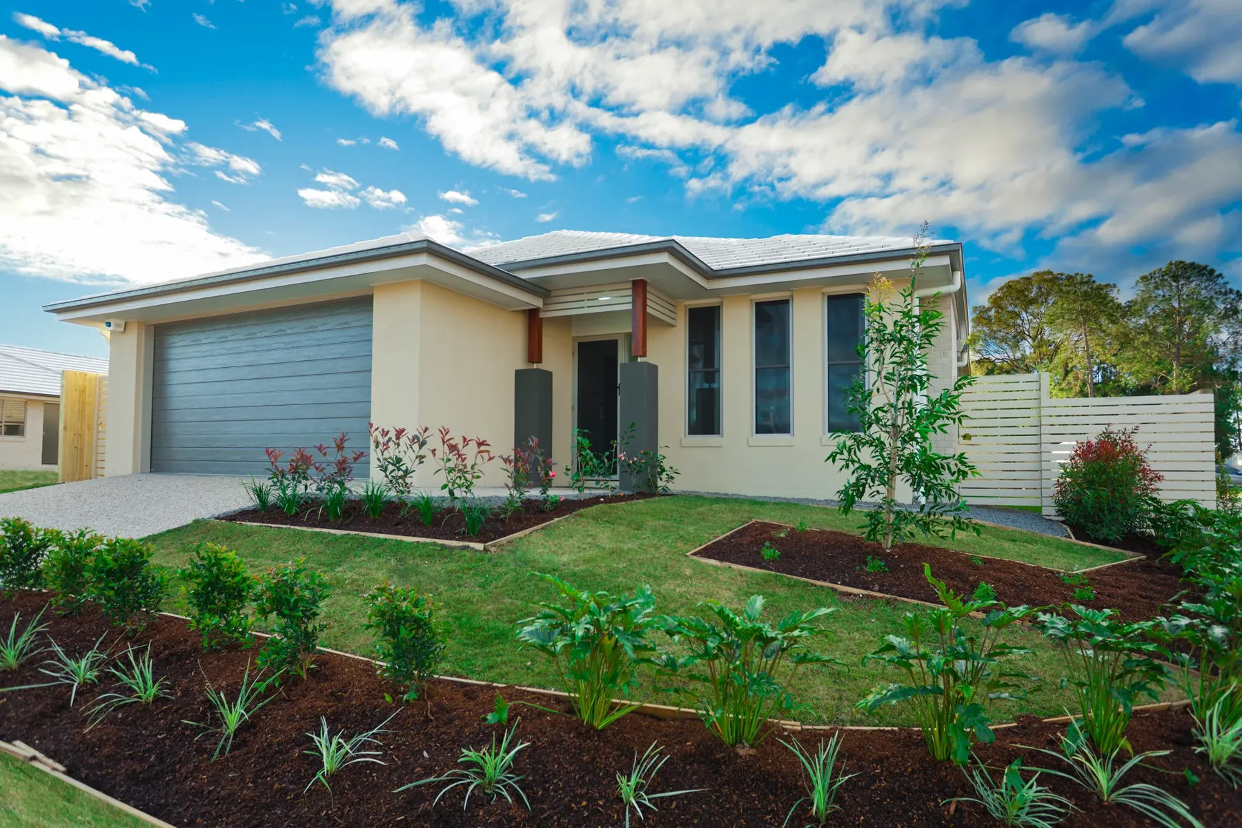 New front garden with freshly planted beds and lawn in front of a modern home