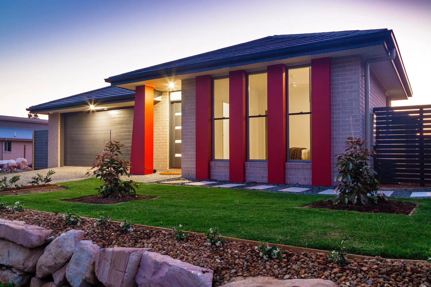 New home with feature garden beds, rock edging and a lawn front yard