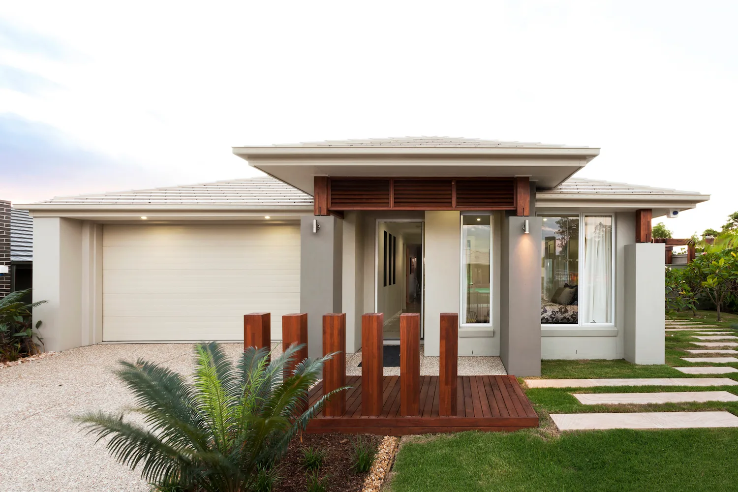 Single-storey home with timber entry deck, screen posts and new garden planting