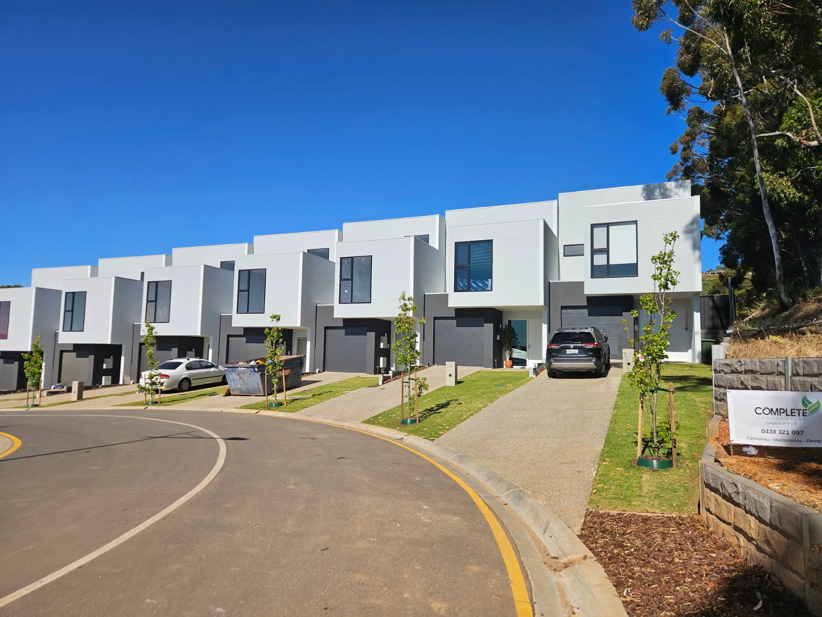 Townhouse development with a low retaining wall, garden beds and new nature strips